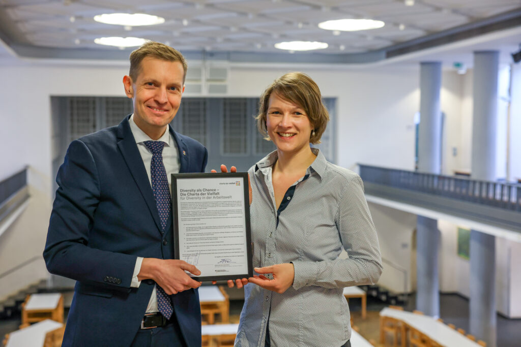 Geschäftsführer Wolfgang Rettich und Ursula Lemmertz präsentieren in der Mensa Stadtmitte die unterzeichnete Charta der Vielfalt